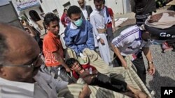 Anti-government protesters carry an injured an injured person into the yard of a Mosque for help following clashes with Yemeni police in Sana'a, Yemen, March 12, 2011