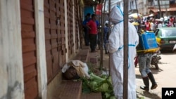 Heath workers collect samples from the body of a person suspected to have died from the Ebola virus, Freetown, Sierra Leone, Oct. 8, 2014.