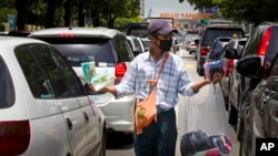 A street vendor sells masks to motorists to protect against the swine flu, July 25, 2017, in Yangon, Myanmar.