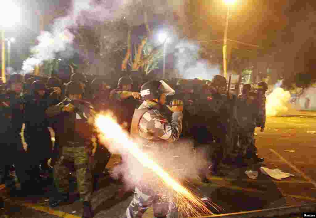 Policajac puca gumenim mecima na demonstrante na protestima održanim kod ušća reke Amazon u Brazilu. 