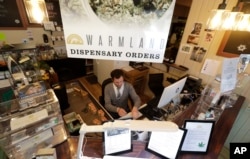 FILE - Bud tender Dave Chelli works at the Warmland Centre, a medical marijuana dispensary in Mill Bay, British Columbia, on Vancouver Island, Sept. 24, 2018.