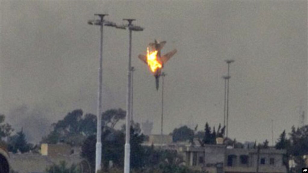 A warplane is seen being shot down over the outskirts of Benghazi, eastern Libya, March 19, 2011