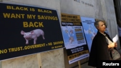 یونان کے ایک بینک کے سامنے سرکاری بانڈز کی واپسی کے لیےاحتجاج