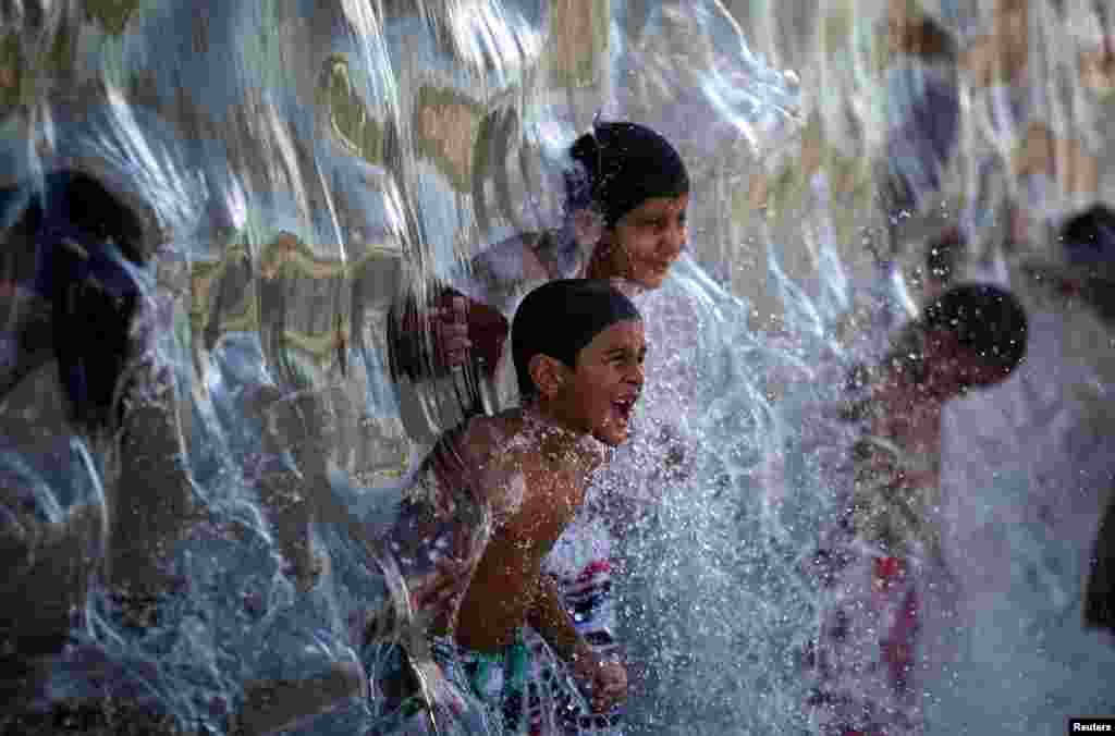 Children play with water in Madureira Park in Rio de Janeiro, Brazil, Feb. 12, 2017.