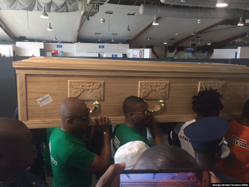 Le corps de Tioté est porté par ses camarades de la sélection à l'aéroport d'Abidjan, le 15 juin 2017. (VOA/Georges Ibrahim Tounkara)