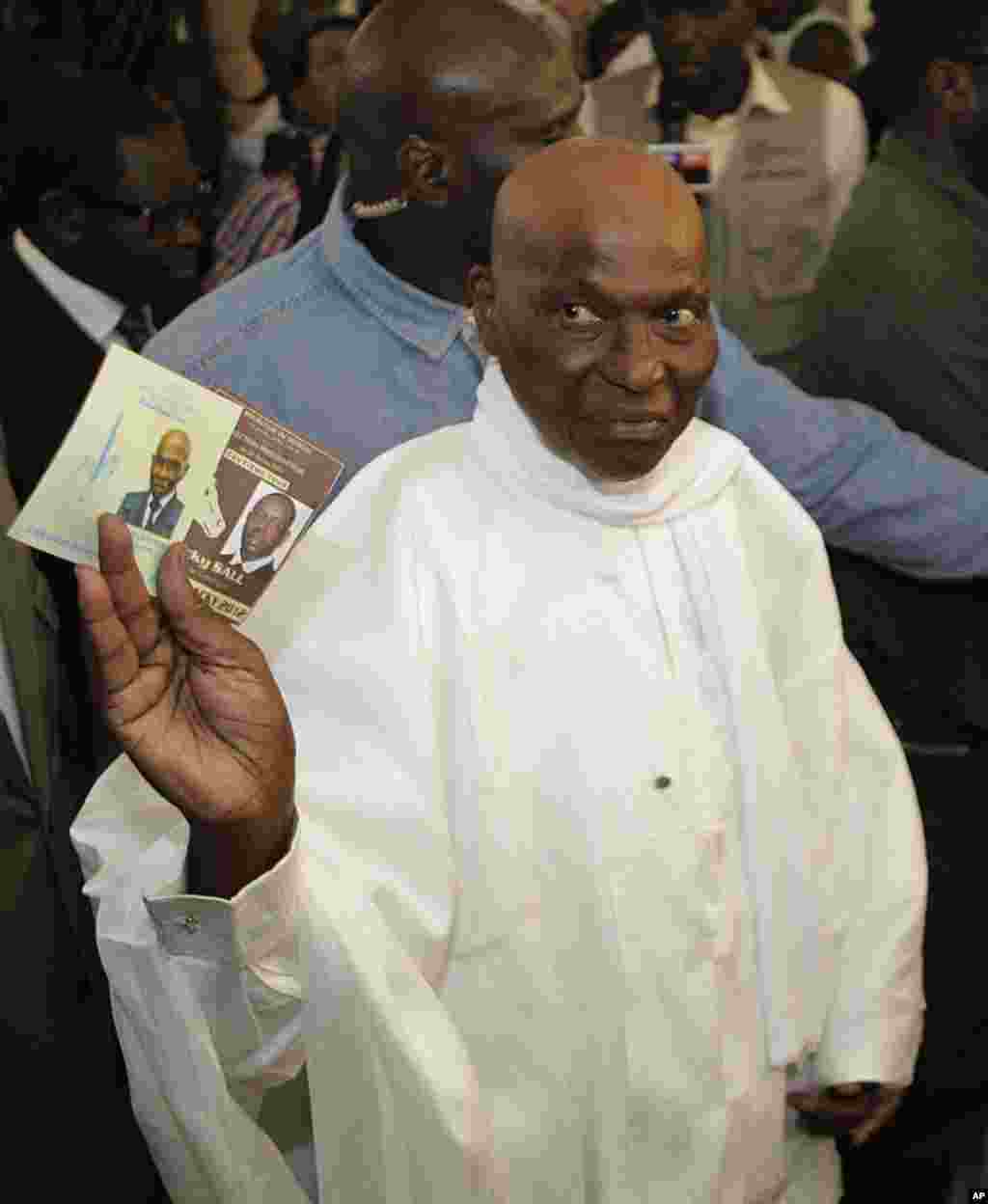 Le président Abdoulaye Wade présentant un bulletin de vote avant de voter au bureau de vote du quartier Point E, à Dakar (AP)