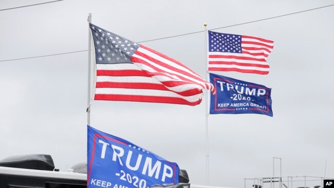 Banderas en apoyo al presidente Donald Trump ondean en vehículos recreativos privados de fanáticos de las carreras de autos que asisten a las 500 Millas de Daytona esta semana en Florida.