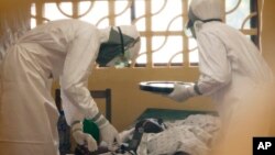 Dr. Kent Brantly (L) treats an Ebola patient at the Samaritan's Purse Ebola Case Management Center in Monrovia, Liberia.