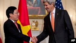 Secretary of State John Kerry shakes hands with Vietnamese Foreign Minister Pham Binh Minh as they speak to media at the State Department in Washington, Oct. 2, 2014, before having a working lunch. (AP Photo/Carolyn Kaster)