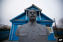 FILE - A bust of Soviet leader Josef Stalin stands on the front lawn of a house-turned-museum in the village of Khoroshevo, west of Moscow, Russia, Dec. 9, 2015. The Stalin museum was opened this year in this small village where the Soviet leader is said to have stayed the night on his only visit to the front during World War II.