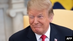 U.S. President Donald Trump smiles during a meeting in the Oval Office at the White House in Washington, March 25, 2019. 