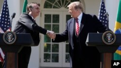President Donald Trump greets Brazilian President Jair Bolsonaro during a news conference in the Rose Garden of the White House, March 19, 2019.