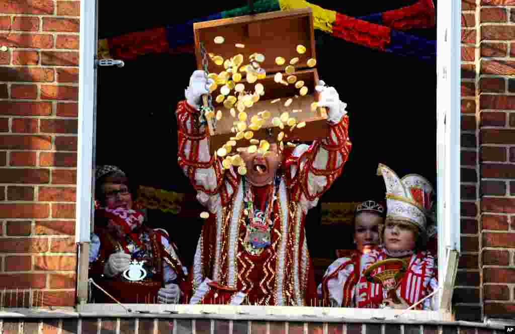 El príncipe del carnaval Jens II simbólicamente lanza el contenido del cofre de la ciudad a través de una ventana, después de asaltar el municipio de la ciudad en Marne, al norte de Alemania. Este espectáculo es visto por miles de personas y se considera parte de la temporada de carnaval en el llamado Lunes de Rosas. 