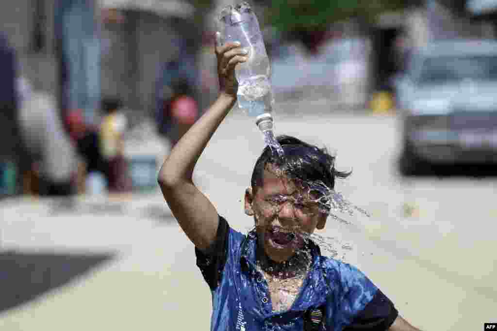 A Palestinian boy pours water over his head in Khan Yunis in the southern Gaza Strip.