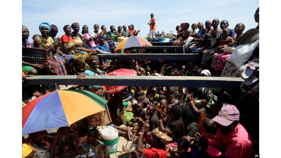 FILE - Refugees who fled Burundi's violence and political tension sing in a speedboat taking them to a ship freighted by the U.N., at Kagunga on Lake Tanganyika, Tanzania, May 23, 2015, to be taken to the port city of Kigoma.