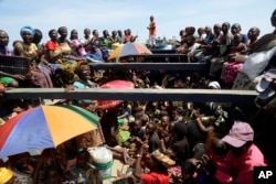 FILE - Refugees who fled Burundi's violence and political tension sing in a speedboat taking them to a ship freighted by the U.N., at Kagunga on Lake Tanganyika, Tanzania, May 23, 2015, to be taken to the port city of Kigoma.