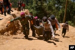 Tim penyelamat membawa mayat seorang korban tambang emas yang roboh dengan tandu di bukit terjal di Bolaang Mongondow, Sulawesi Utara, Selasa, 5 Maret 2019.