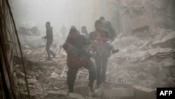 Syrians evacuate victims following air strikes on the town of Douma in the eastern Ghouta region, a rebel stronghold east of the capital Damascus, Dec. 13, 2015.