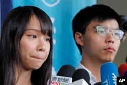 Activistas prodemocracia Agnes Chow y Joshua Wong, hablan con la prensa afuera de una corte de distrito en Hong Kong, el viernes 30 de agosto de 2019.
