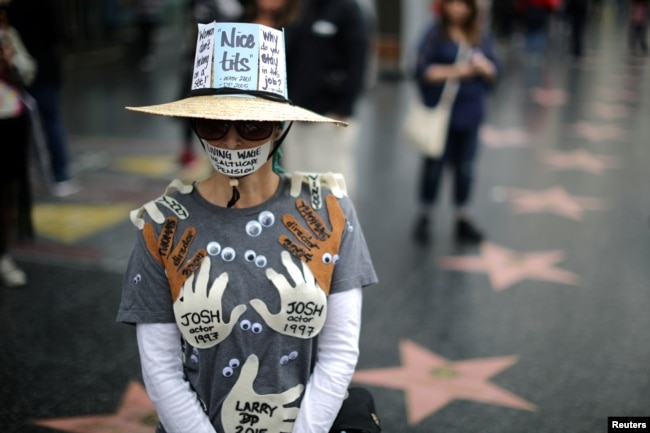 A woman who declined to give her name wears an outfit with the names of all the men in Hollywood she says sexually harassed her, during a protest march for survivors of sexual assault and their supporters in Hollywood, Los Angeles, California, Nov. 12, 2017.