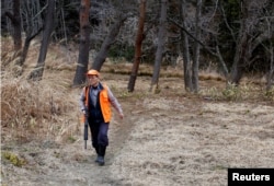 Shoichiro Sakamoto, head of Tomioka Town's animal control hunters group, patrols at a residential area in an evacuation zone near Tokyo Electric Power Co's tsunami-crippled Fukushima Daiichi nuclear power plant in Tomioka town, Fukushima prefecture, Japa