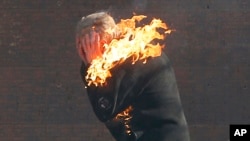 An anti-government protester is engulfed in flames during clashes with riot police outside Ukraine's parliament in Kyiv, Feb. 18, 2014. 