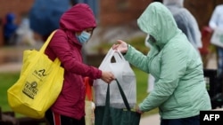 Volonteri organizacije Baltimore Hunger Project dele hranu ispred Međunarodne osnovne škole Padonia u Kokisvilu u Merilendu, 4. decembra 2020. 