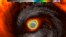 This false-color satellite image provided by the National Oceanic and Atmospheric Administration (NOAA) shows the moment the eye of Super Typhoon Yutu passed over Tinian, one of three main islands in the U.S. Commonwealth of the Northern Mariana Islands, producing damaging winds and high surf Oct. 24, 2018. 