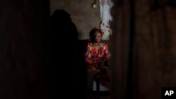 Sifa Kunguja, a 40-year-old sex worker, sits home after recovering from mpox, Sept. 4, 2024, in Kamituga, eastern Congo. 