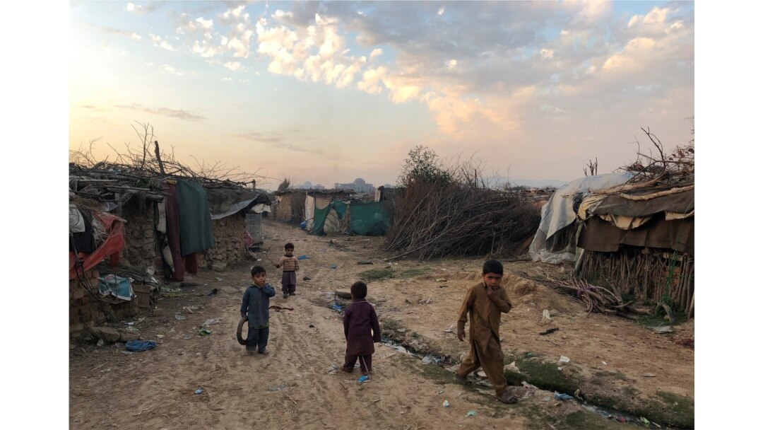 FILE - Children play outside their family's shelters at an Afghan refugee camp in Islamabad, Pakistan, Feb. 13, 2020.