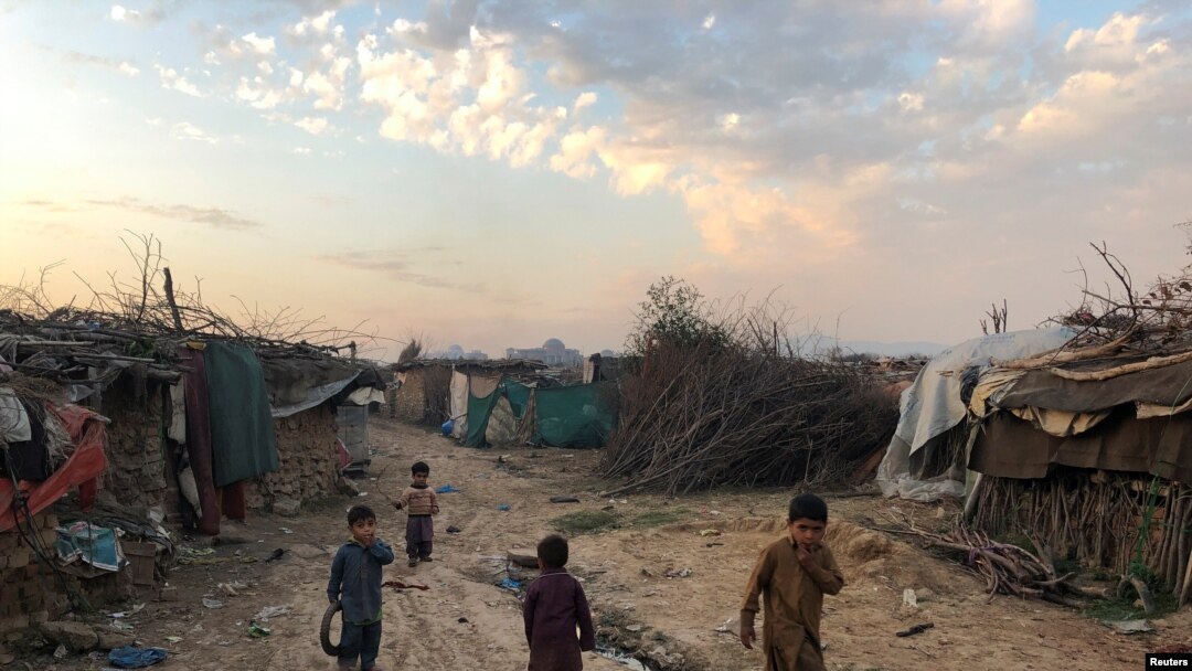 Children play outside their family's shelters at Afghan refugee camp in Islamabad, Pakistan, Feb. 13, 2020. 