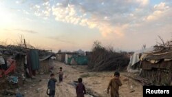 Children play outside their family's shelters at Afghan refugee camp in Islamabad, Pakistan, Feb. 13, 2020. 