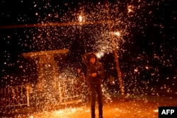 FILE —A Palestinian child plays with a sparkler in Rafah on the eve of Ramadan on March 10, 2024, amid ongoing battles between Israel and Hamas.