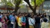People gather outside the embassy of Thailand to get visas in Yangon, Feb. 16, 2024, after Myanmar's military government said it would impose military service.