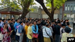 People gather outside the embassy of Thailand to get visas in Yangon, Feb. 16, 2024, after Myanmar's military government said it would impose military service.