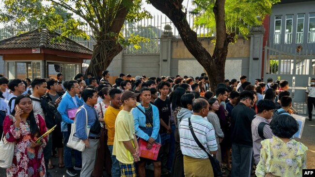 FILE - People gather outside the embassy of Thailand to get visas in Yangon on Feb. 16, 2024, after Myanmar's military government said it would impose military service.