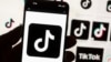 FILE - The TikTok logo is displayed on a mobile phone in front of a computer screen, Oct. 14, 2022. TikTok announced on Sept. 23, 2024, that it had removed accounts of Russian state media organizations, accusing them of "covert influence operations."