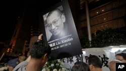 Manifestantes lamentan la muerte del encarcelado premio Nobel de la Paz Liu Xiaobo durante una manifestación frente al oficina de vínculo chino en Hong Kong, el jueves, 13 de julio de 2017.