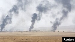 FILE - Smoke rises in the aftermath of clashes with Islamic State militants on the southeast of Mosul, Iraq, Aug. 14, 2016.