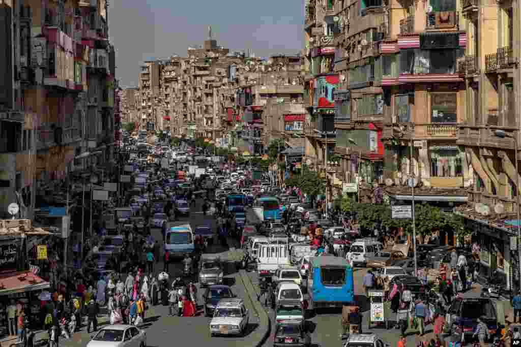 People crowd a street a few hours ahead of curfew in Cairo, Egypt. The government has imposed a nationwide curfew from 8 p.m. to 6 a.m due to the coronavirus outbreak.