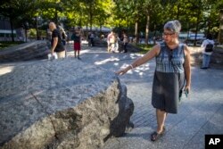 Seorang pengunjung menyentuh salah satu granit di monumen peringatan serangan teror 11 September 2011 -- 9/11 Memorial Glade, di New York, 29 Agustus 2019.