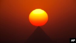 FILE - The sun sets over the the Giza Pyramids, near Cairo, Egypt, August 19, 2016.