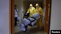 지난 14일 벨기에 브뤼셀의 요양소에서 장의 직원들이 신종 코로나바이러스 감염증(COVID-19) 사망자 시신을 옮기고 있다.