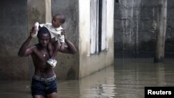 Un habitant de Lagos porte un enfant dans le quartier d'Ikorodu, inondé en août 2007  