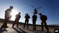 FILE - American soldiers wait on the tarmac in Logar province, Afghanistan, Nov. 30, 2017.