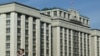 FILE - A woman walks past the building of the Russian State Duma (lower house of the Parliament) in central Moscow on Sept. 24, 2024.