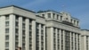 FILE - A woman walks past the building of the Russian State Duma (lower house of the Parliament) in central Moscow on Sept. 24, 2024.