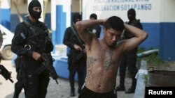One of 13 suspected members of the 18th street gang is presented to the media after being arrested by the police under the charges of homicide and terrorism, in Soyapango, El Salvador, March 31, 2016. 