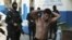 FILE - One of 13 suspected members of the 18th street gang is presented to the media after being arrested by the police under the charges of homicide and terrorism, in Soyapango, El Salvador.