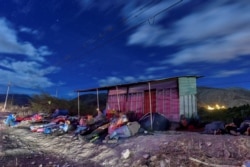FILE - Venezuelan migrants on their way to Peru sleep along the Pan-American Highway between Tulcan and Ibarra in Ecuador, after entering the country from Colombia, Aug. 22, 2018.